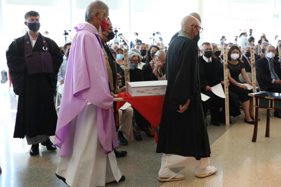 Clergy carry book into ceremony